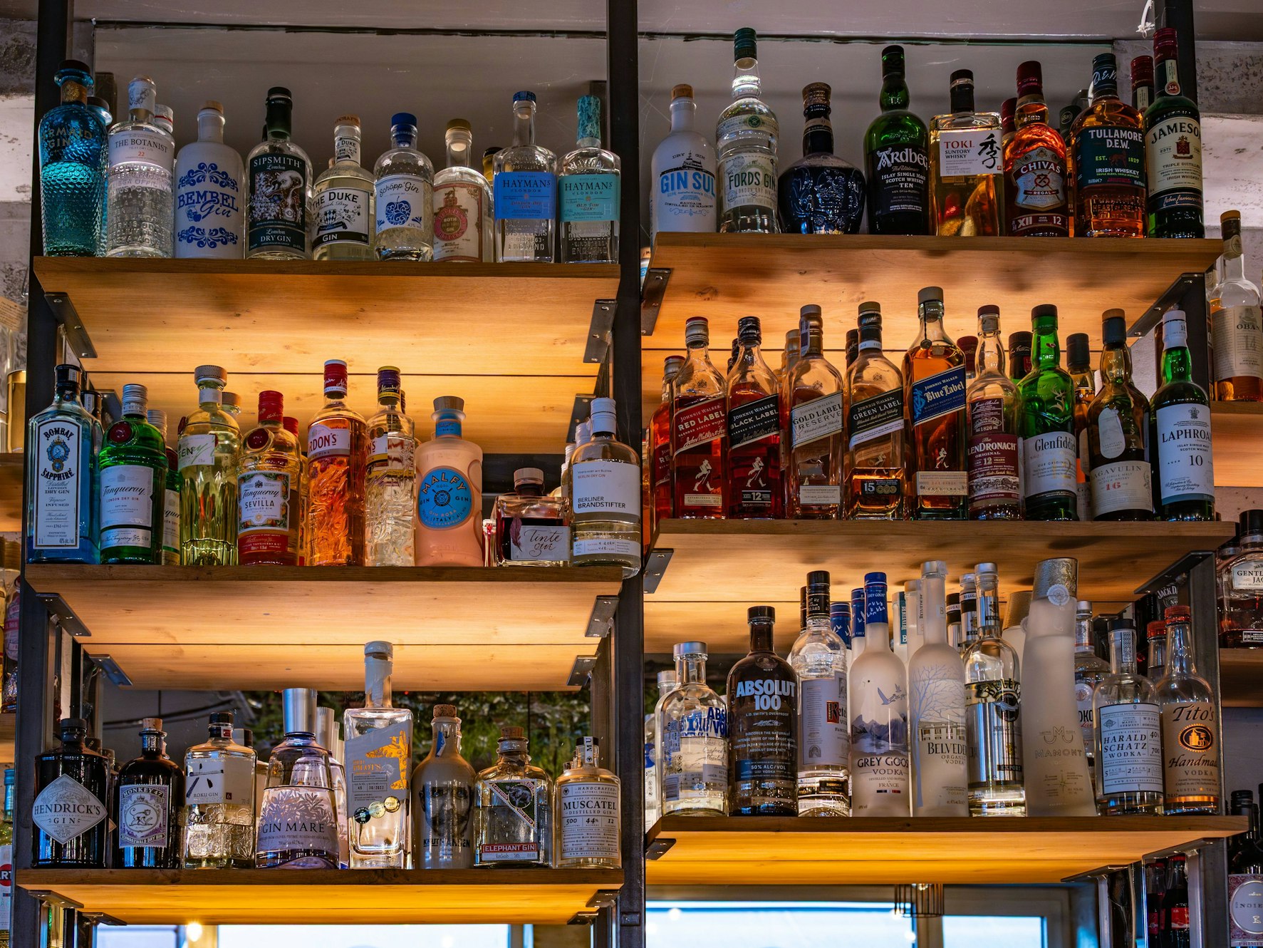 Die Polizei Lübeck prüft derzeit Hinweise, ob es beim Ausschank zu einer Verwechslung von Reinigungsmittel und einem alkoholischen Getränk gekommen sein könnte. Das Symbolfoto zeigt ein Regal mit verschiedenen Flaschen alkoholhaltiger Getränke in einer Bar und steht nicht im direkten Zusammenhang mit dem Timmendorfer Fall.