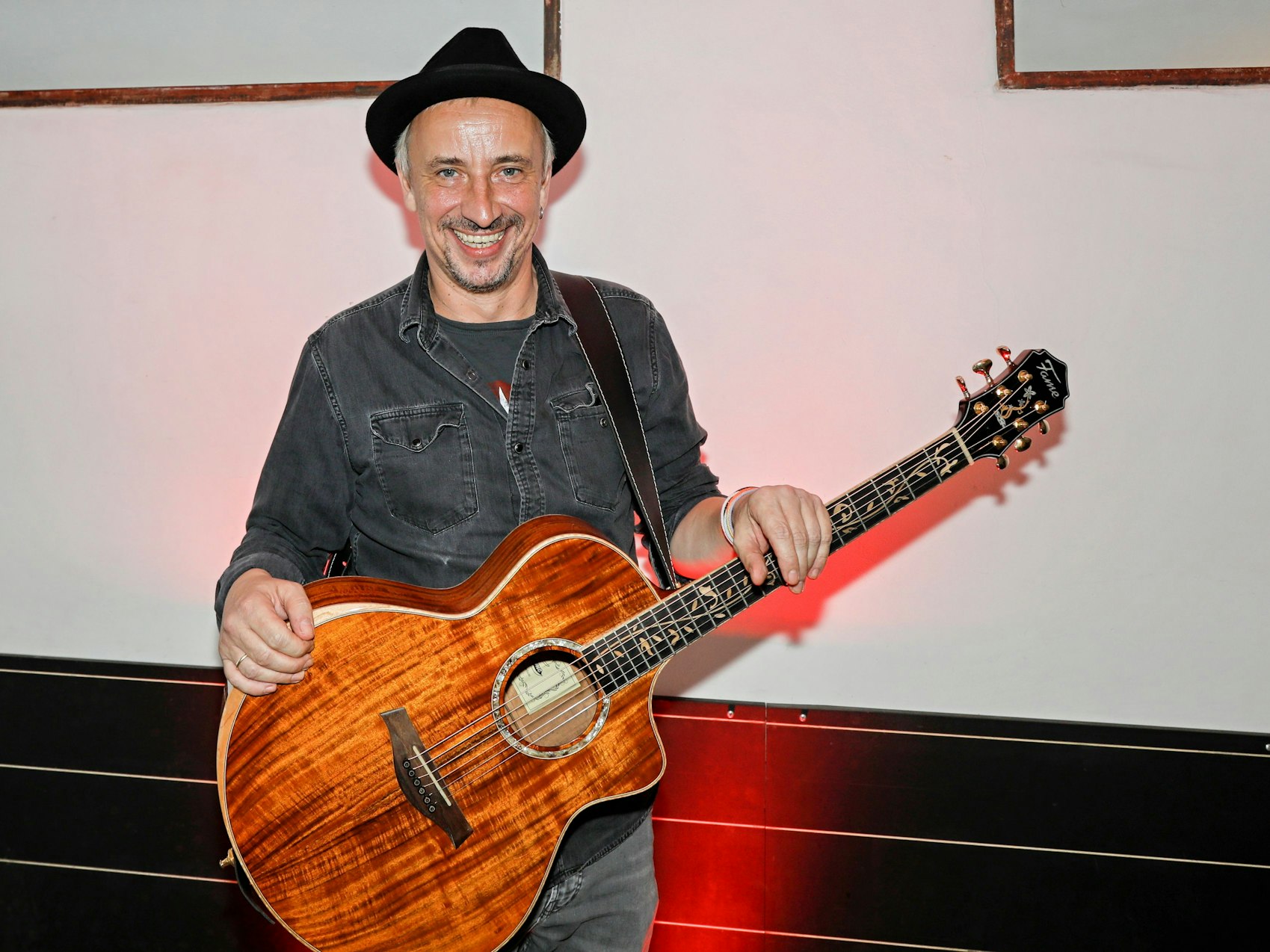 Stefan Knittler steht mit seiner Gitarre im Foyer.