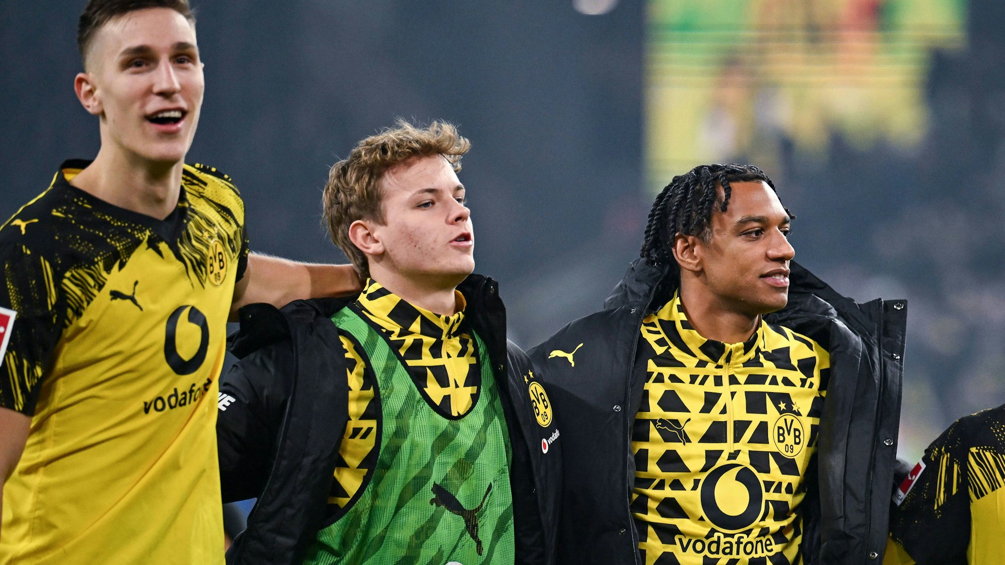Nico Schlotterbeck, Cole Campbell und Filipo Mane stehen nach einem Sieg vor den Fans. Schlotterbeck und Mane lächeln, Campbell guckt weniger glücklich.