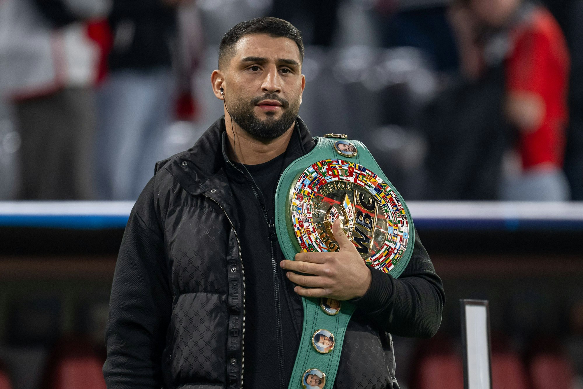 Agit Kabayel mit WM-Gürtel über der Schulter als Gast im Stadion.