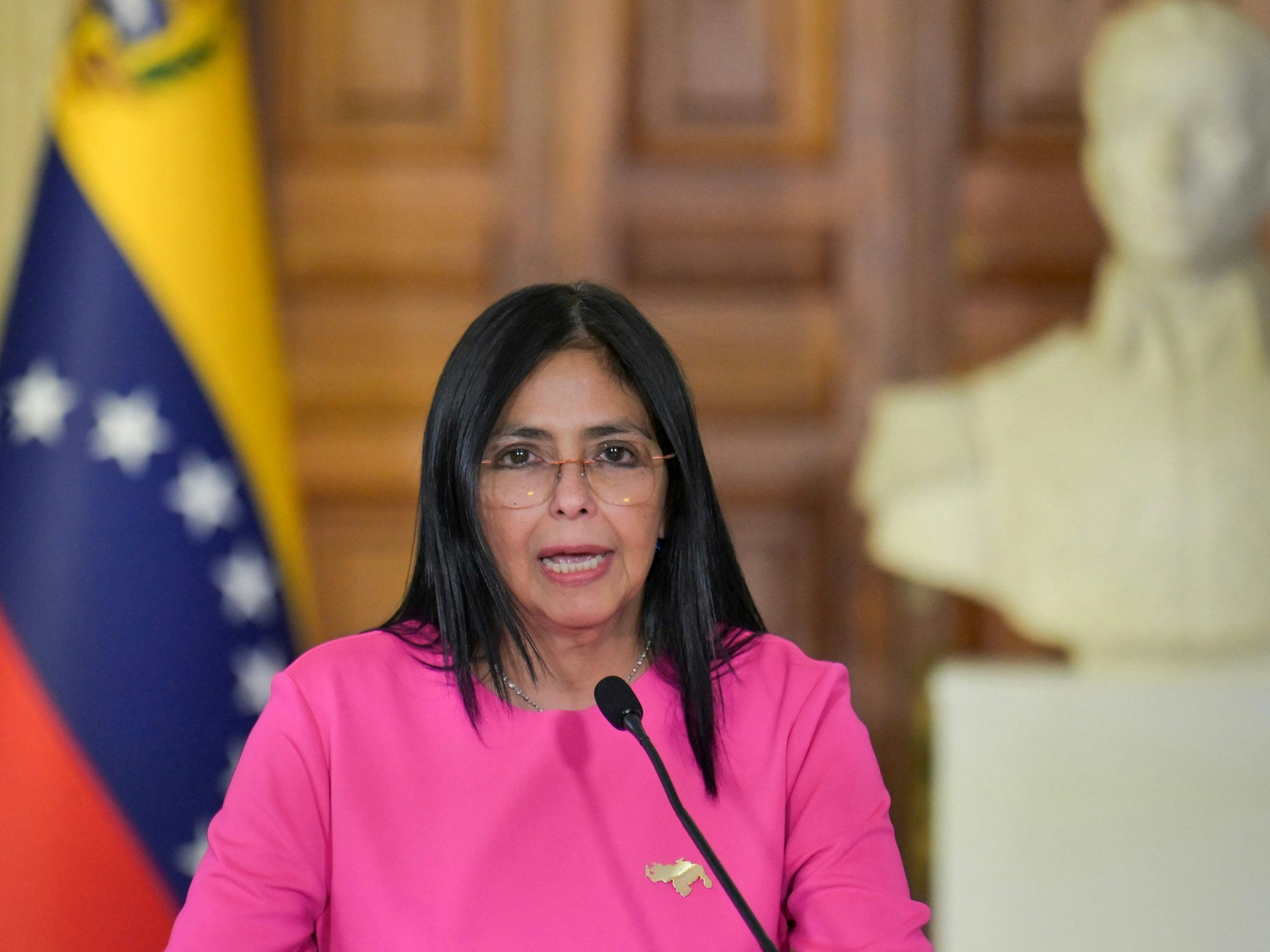 Venezuelas Vizepräsidentin Delcy Rodríguez spricht in ein Mikrofon.