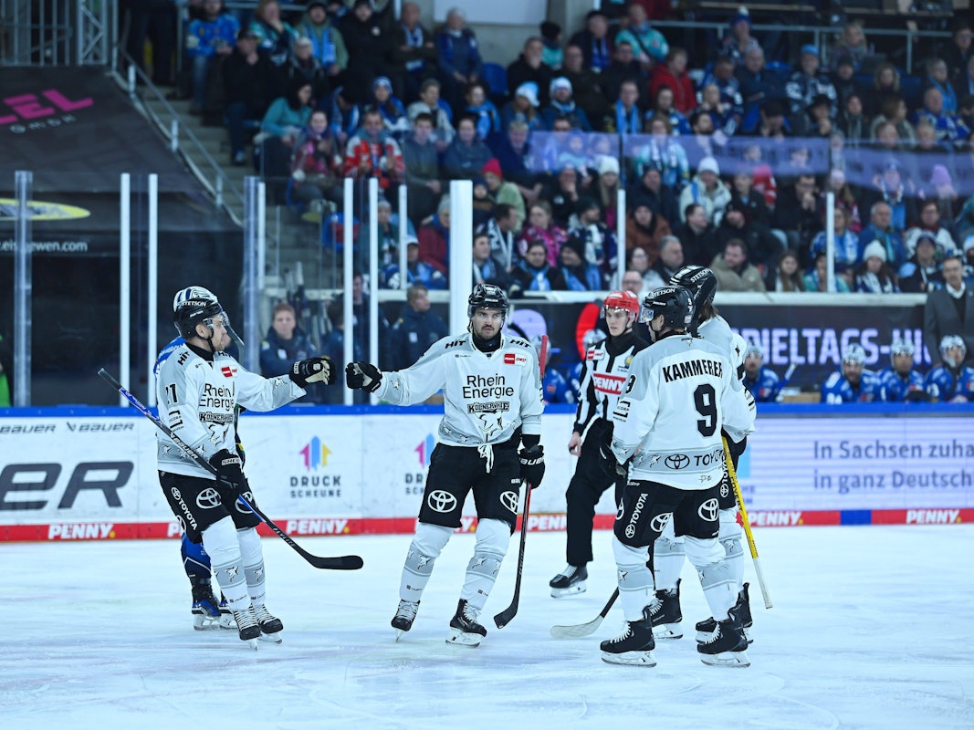 Die Spieler der Kölner Haie klatschen sich nach einem Treffer ab.