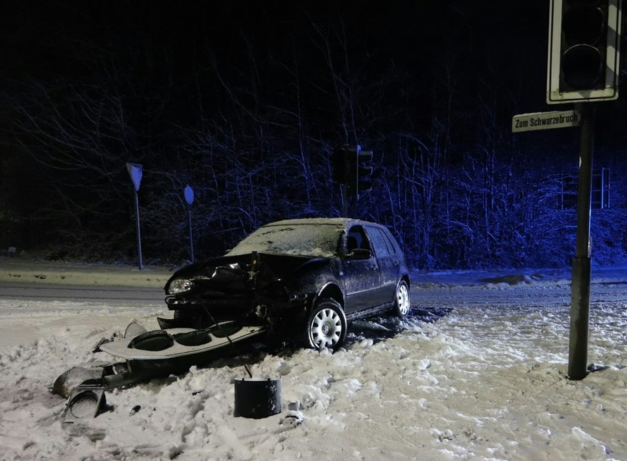 Ein VW Golf steht nach einem Unfall an einer beschädigten Ampel.