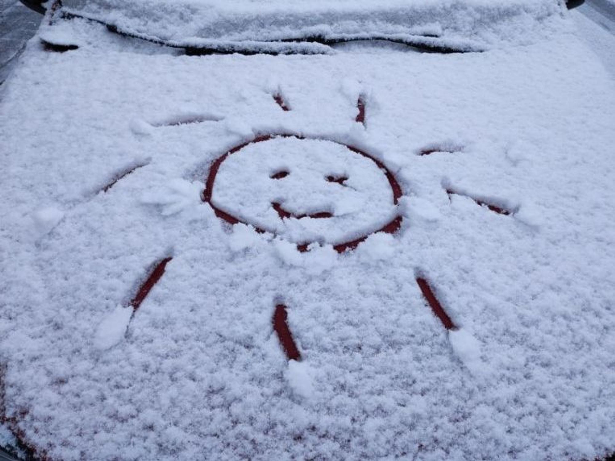 Ein Schneegesicht auf einem Auto in Köln.