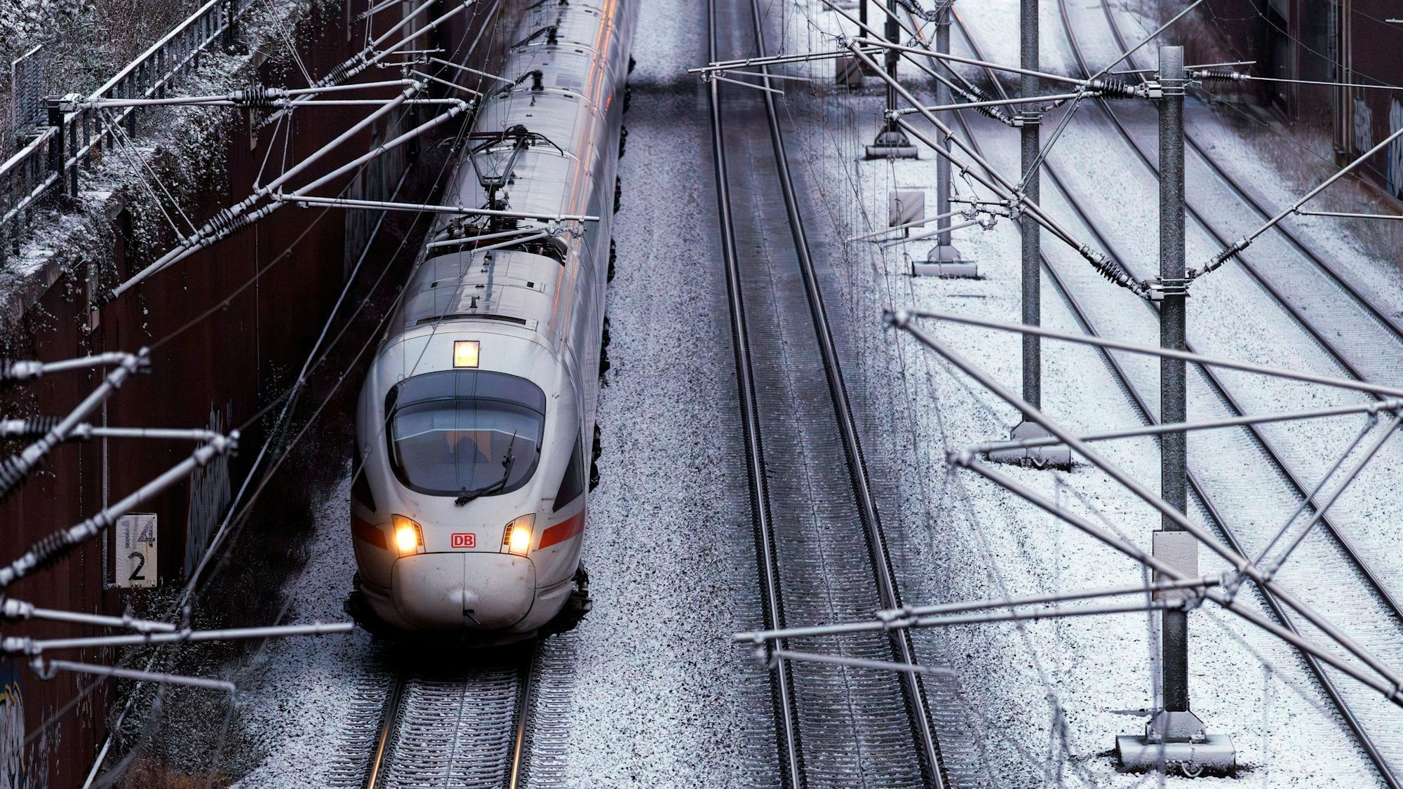 Zug fährt auf schneebedeckten Gleisen