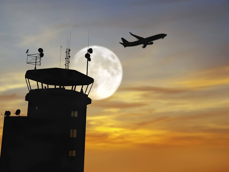 Flugzeug und Flugsicherungsturm vor Vollmond