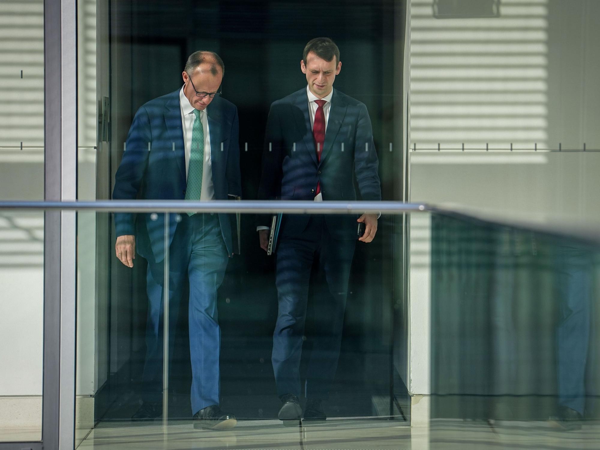 Friedrich Merz und sein bisheriger Büroleiter Jacob Schrot gehen nebeneinander
