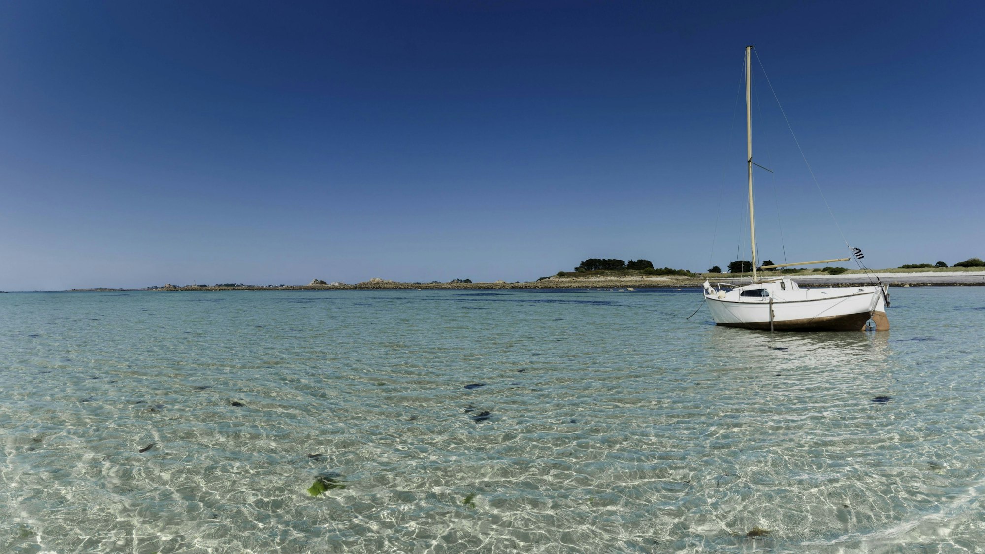 Segelboot im klaren Wasser unter blauem Himmel