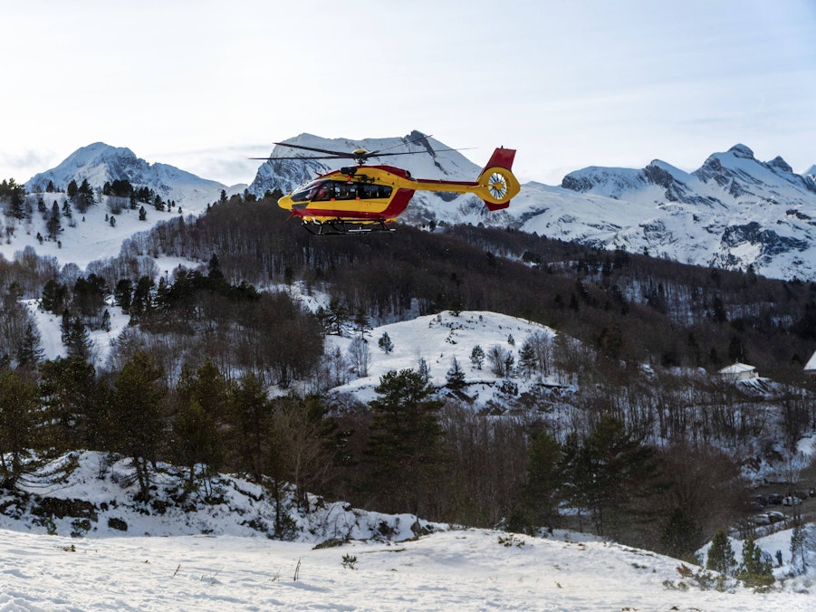 Rettungshubschrauber über verschneiten Bergen