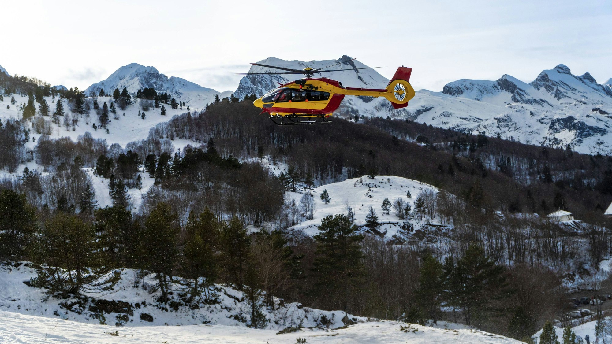 Rettungshubschrauber über verschneiten Bergen