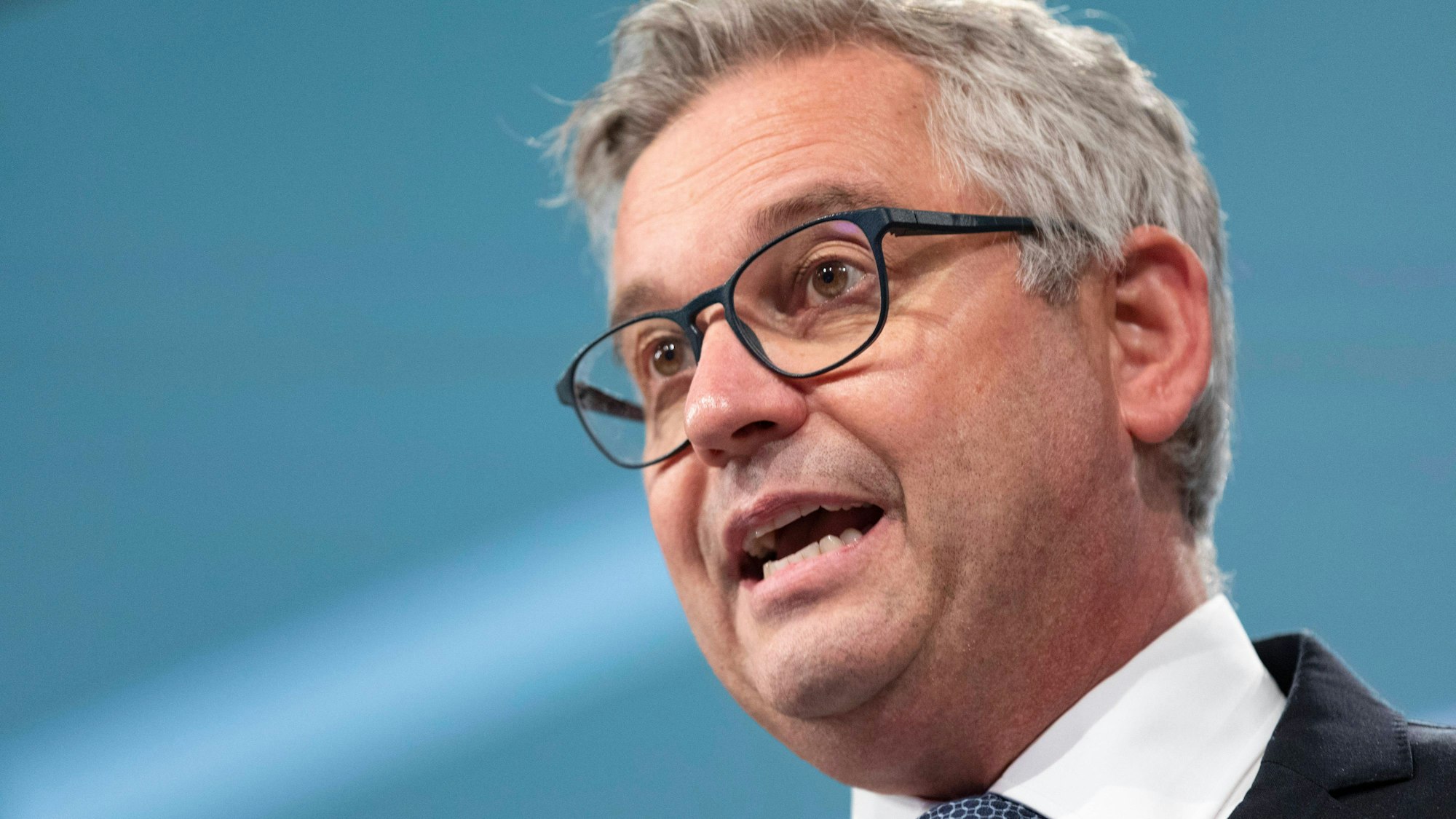 Kommissar Brunner mit Brille und Anzug spricht