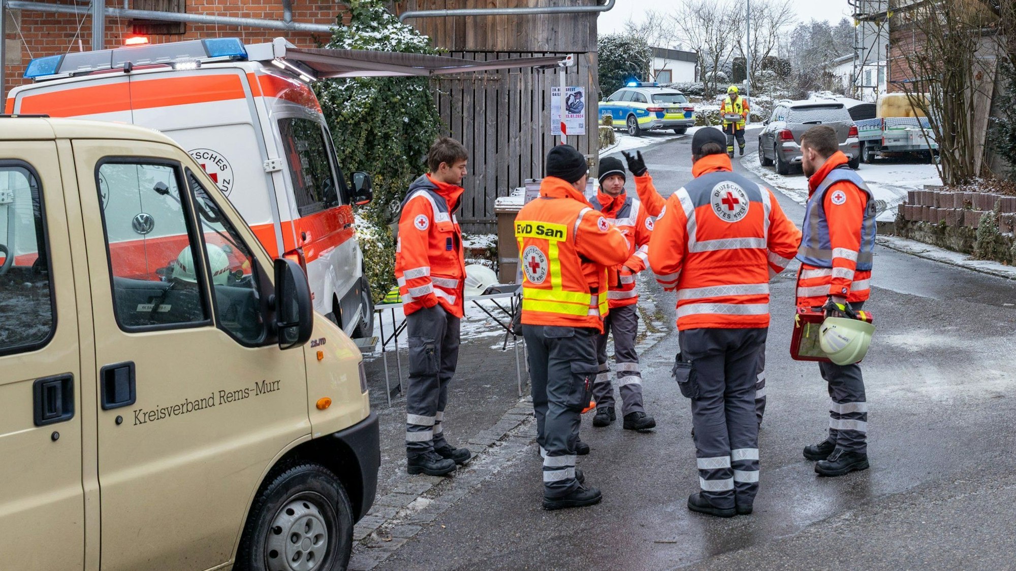 Einsatzkräfte stehen nahe der Unglücksstelle, nachdem während eines Einsatzes der Feuerwehr und des Rettungsdienstes wegen eines medizinischen Notfalls ein Treppenhaus in einem Einfamilienhaus eingestürzt war.