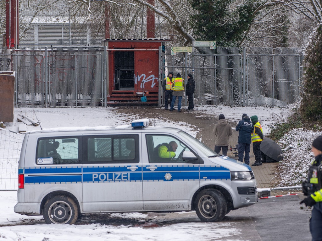 Einsatzkräfte der Polizei stehen an der Brandstelle einer Kabelbrücke vor dem Kraftwerk Lichterfelde am Teltowkanal. Nach dem Brand einer Kabelbrücke ist im Südwesten Berlins für 50.000 Haushalte und 2.000 Gewerbebetriebe der Strom ausgefallen.