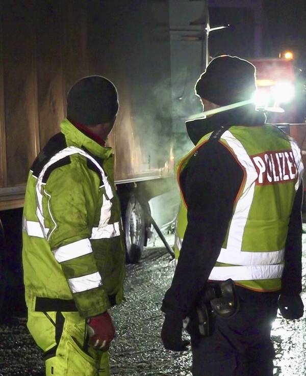Polizisten stehen an einem Unfallort.