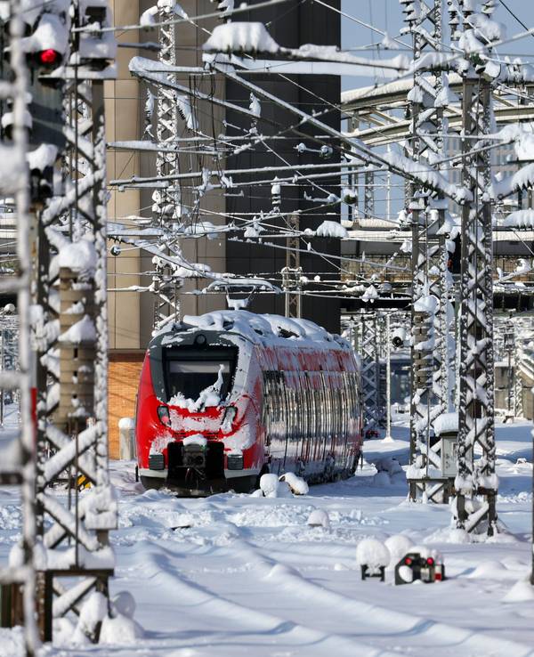 Mit Schnee überzogene Regionalzüge stehen im Hauptbahnhof München.
