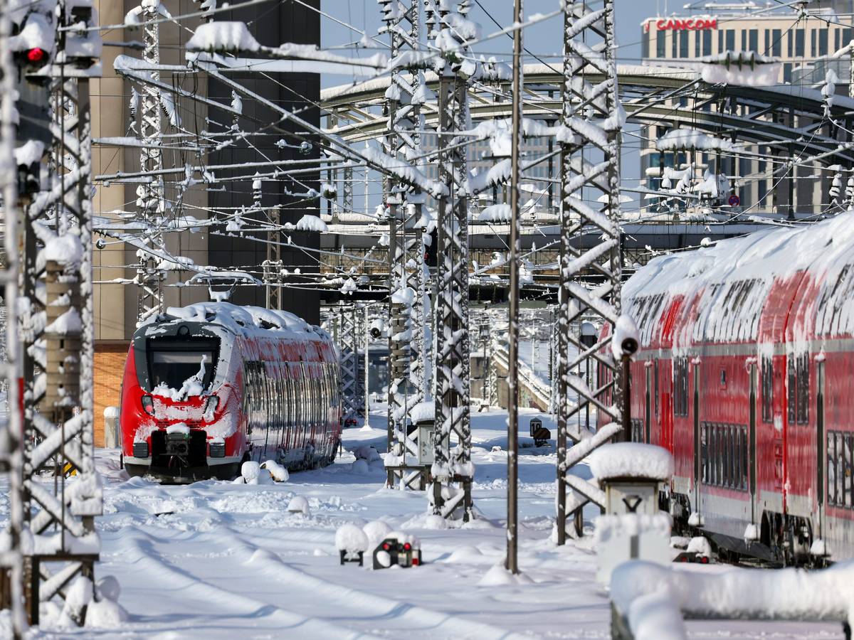 Mit Schnee überzogene Regionalzüge stehen im Hauptbahnhof München.