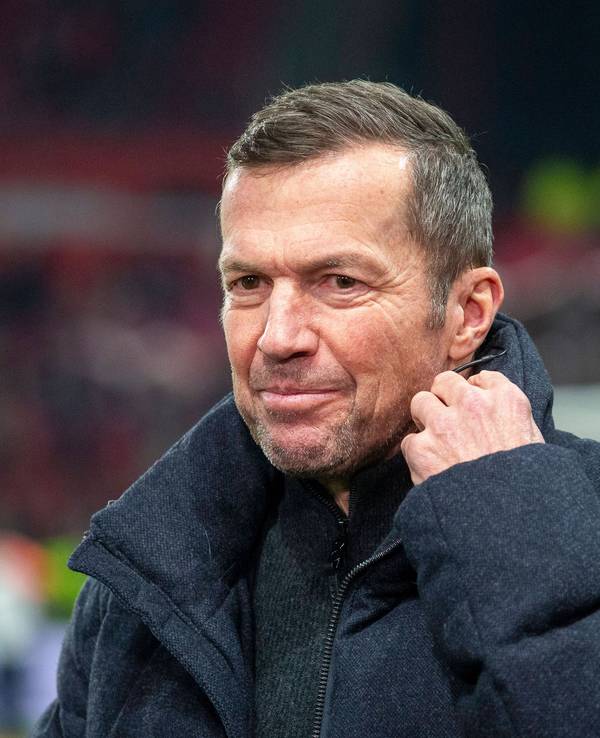Lothar Matthäus richtet sich ein Mikrofon am Kragen.