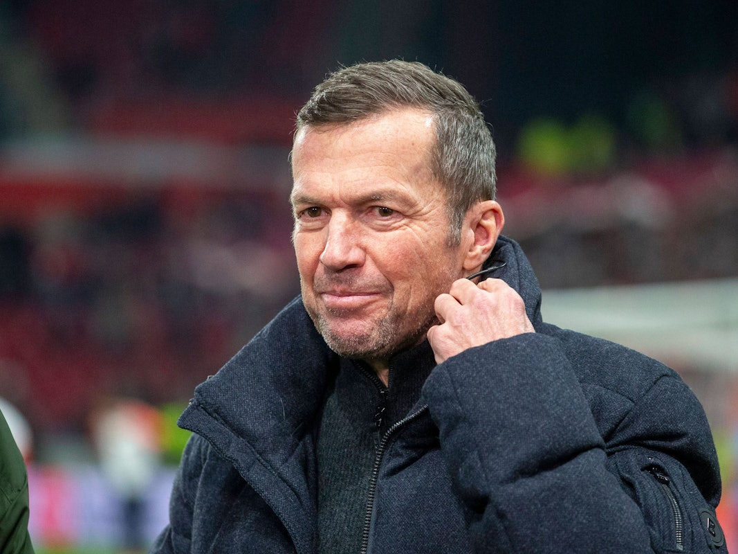 Lothar Matthäus richtet sich ein Mikrofon am Kragen.