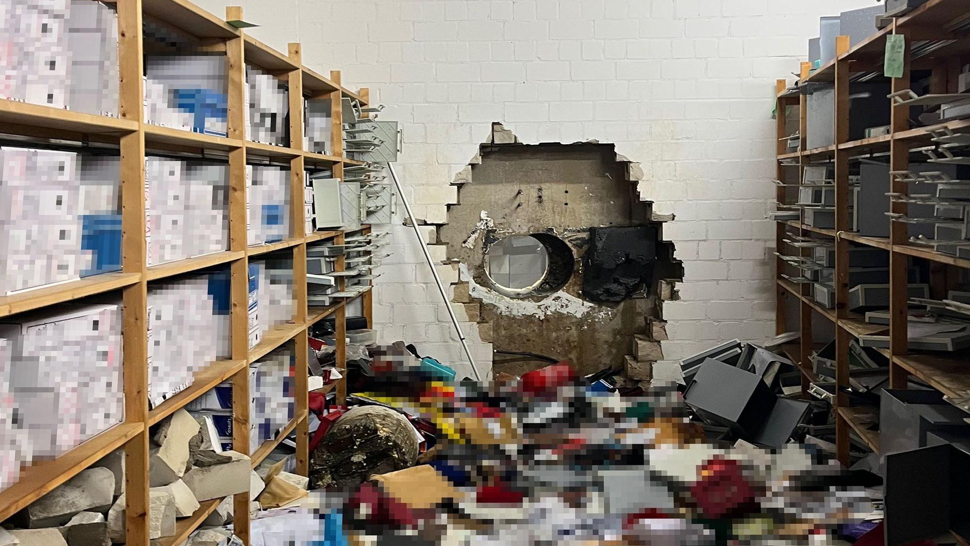 Ein großes Loch ist in der Wand des Tresorraums einer Sparkasse zu sehen. Einbrecher haben sich mit Hilfe eines großen Bohrers Zugang zum Tresorraum verschafft.