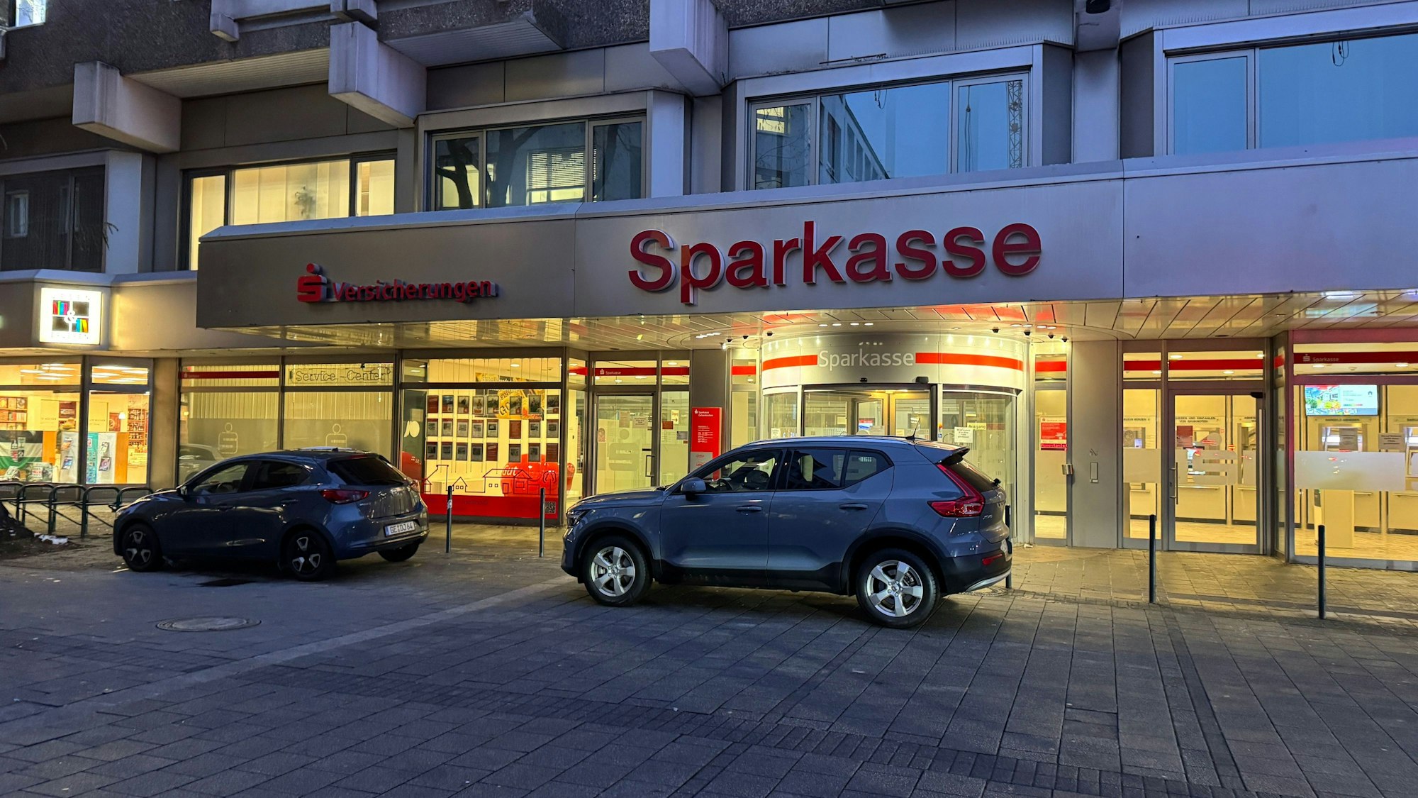 Zivilfahrzeuge stehen vor der Filiale der Sparkasse in Gelsenkirchen. Nach dem spektakulären Millionen-Coup im Stadtteil Buer hat die Polizei das Institut am Dienstag durchsucht.