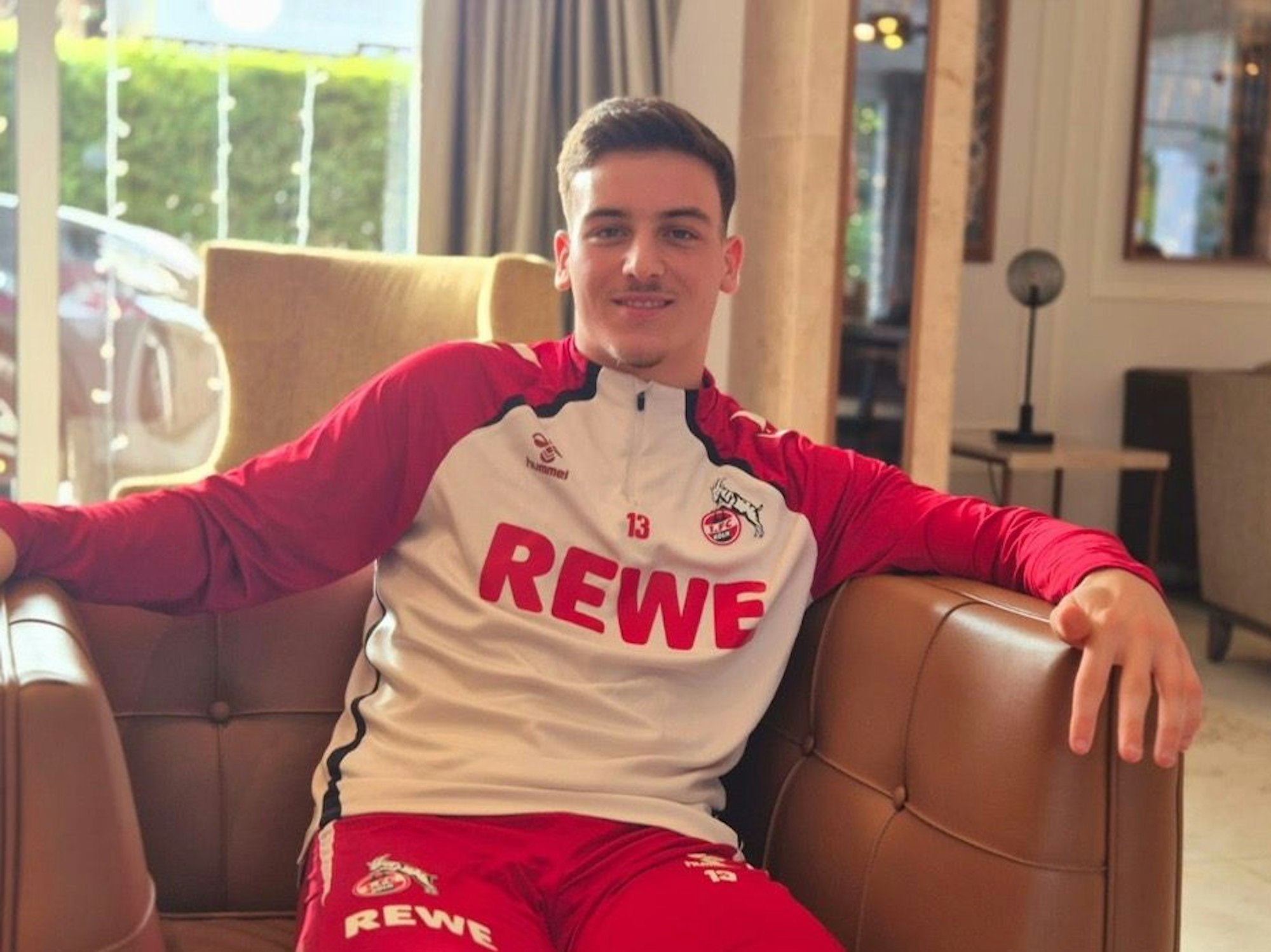 Said El Mala sitzt mit FC-Trainingsanzug in einem Ledersessel.