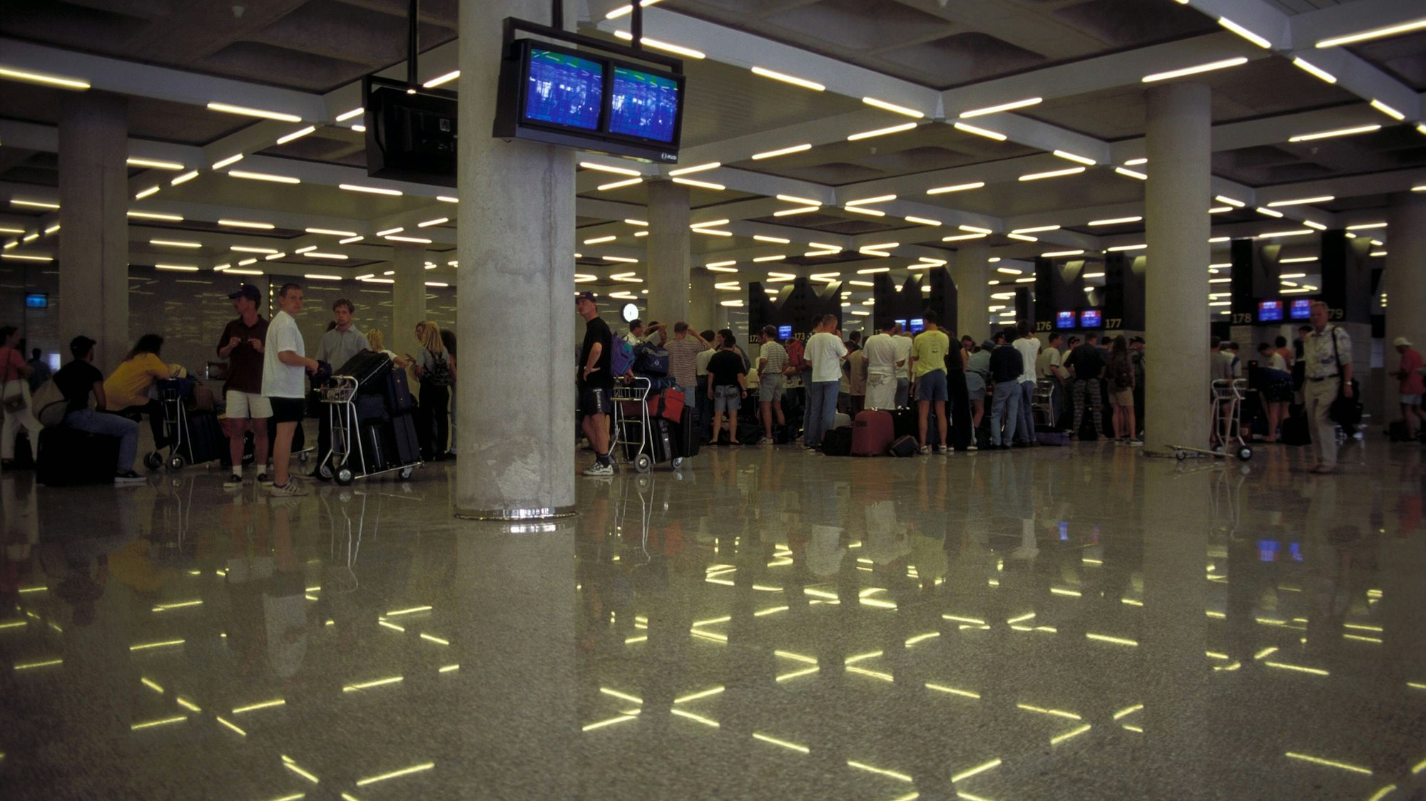 Menschen stehen in einer beleuchteten Halle