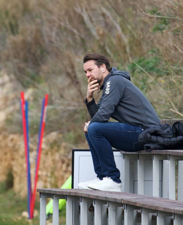 Thomas Kessler sitzt beim Training des 1. FC Köln auf einer Bank.
