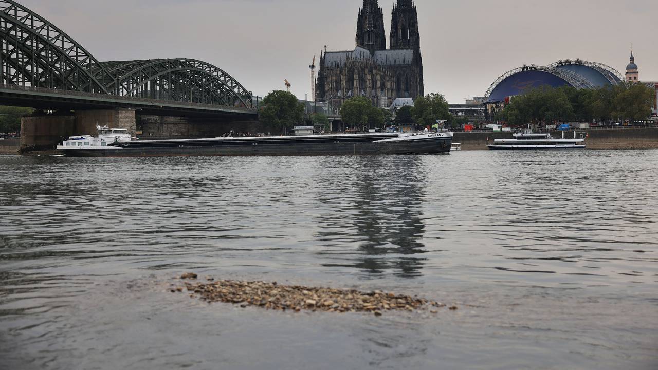 Ein Schiff fährt bei Niedrigwasser über den Rhein unter der Hohenzollernbrücke am Kölner Dom vorbei.