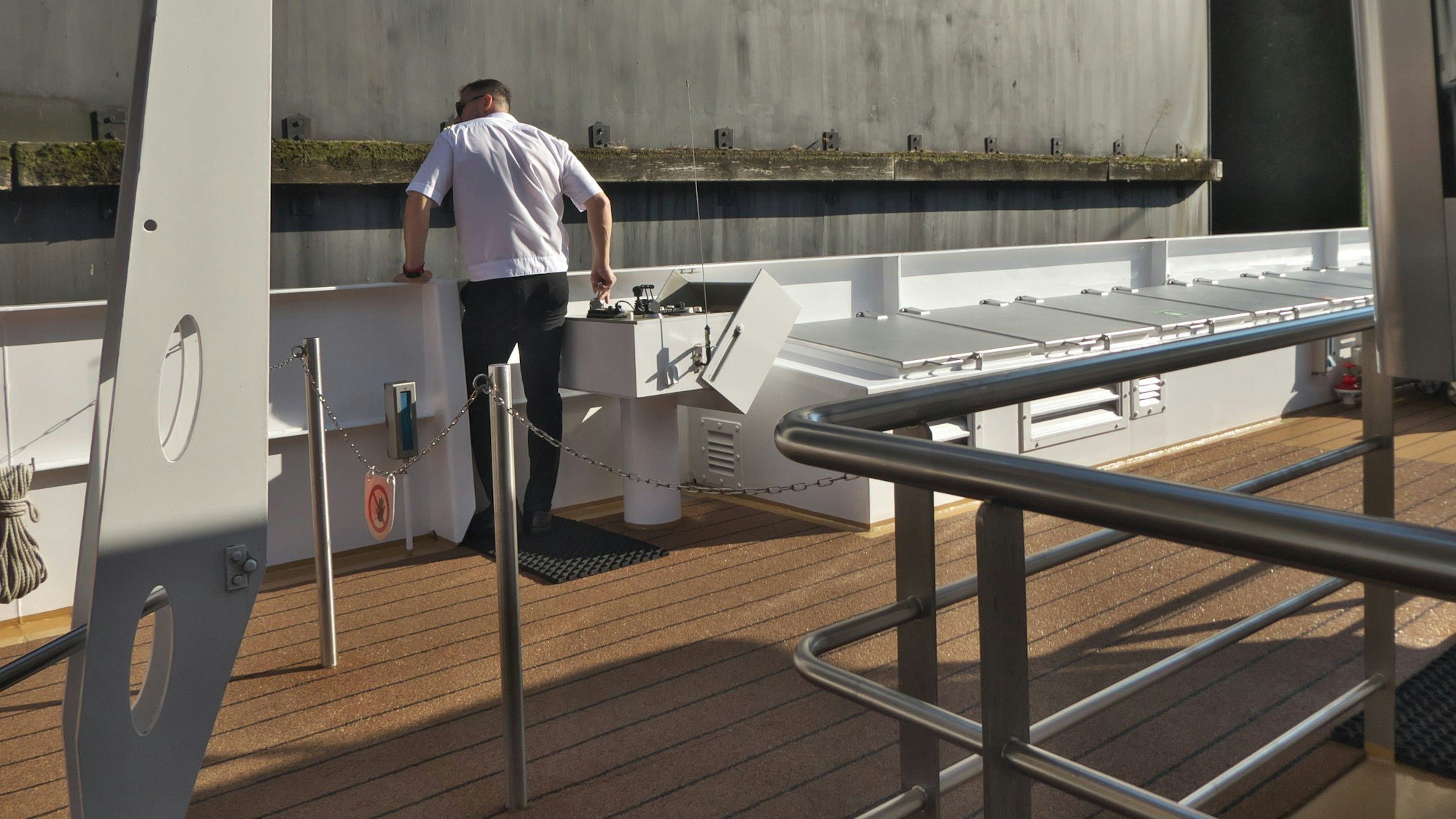 Mann steuert Schiff in Schleuse