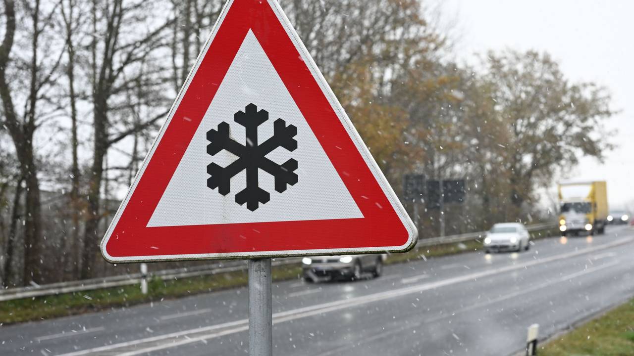 Ein Verkehrszeichen an einer Straße weist auf mögliche Glätte auf der Fahrbahn hin.