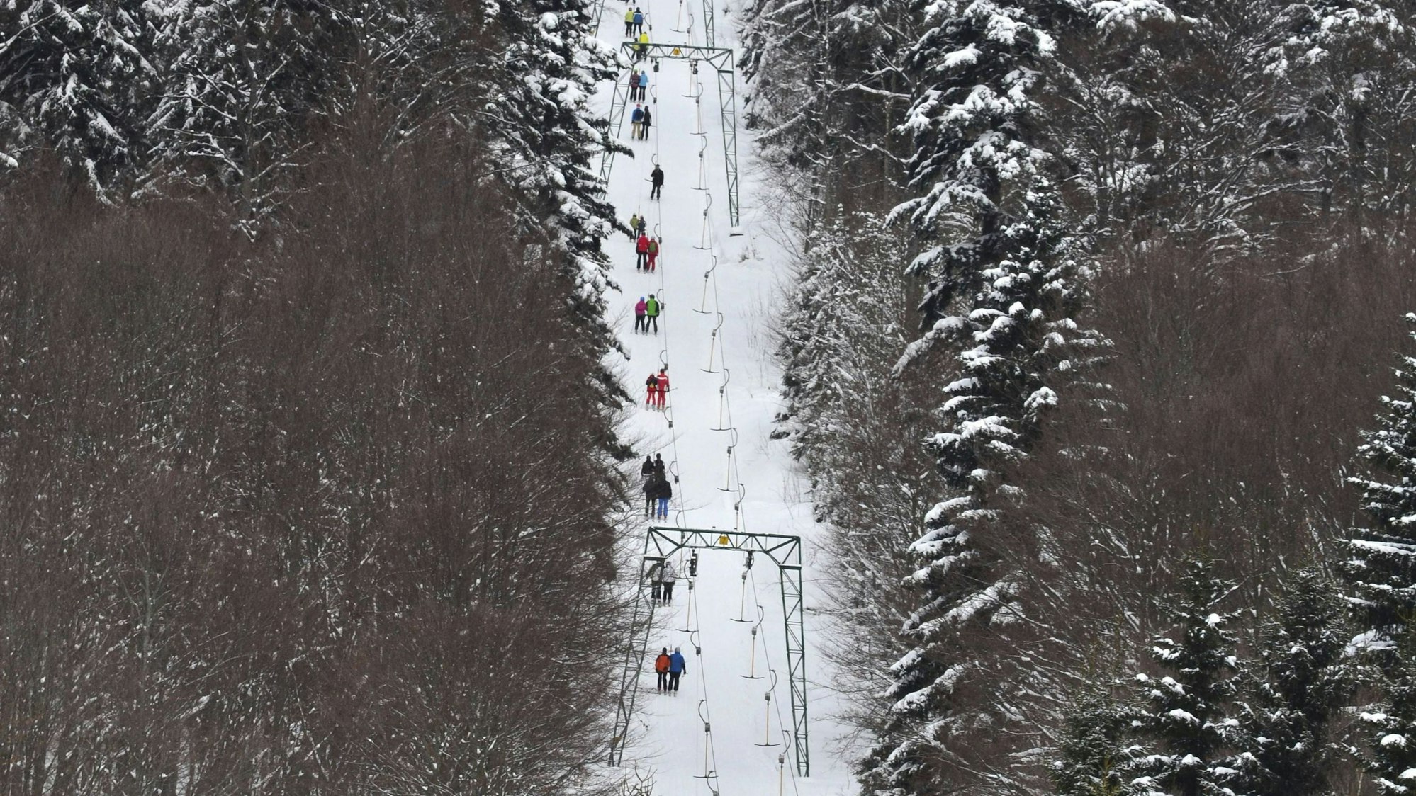 Skilift mit Fahrgästen in verschneiter Winterlandschaft