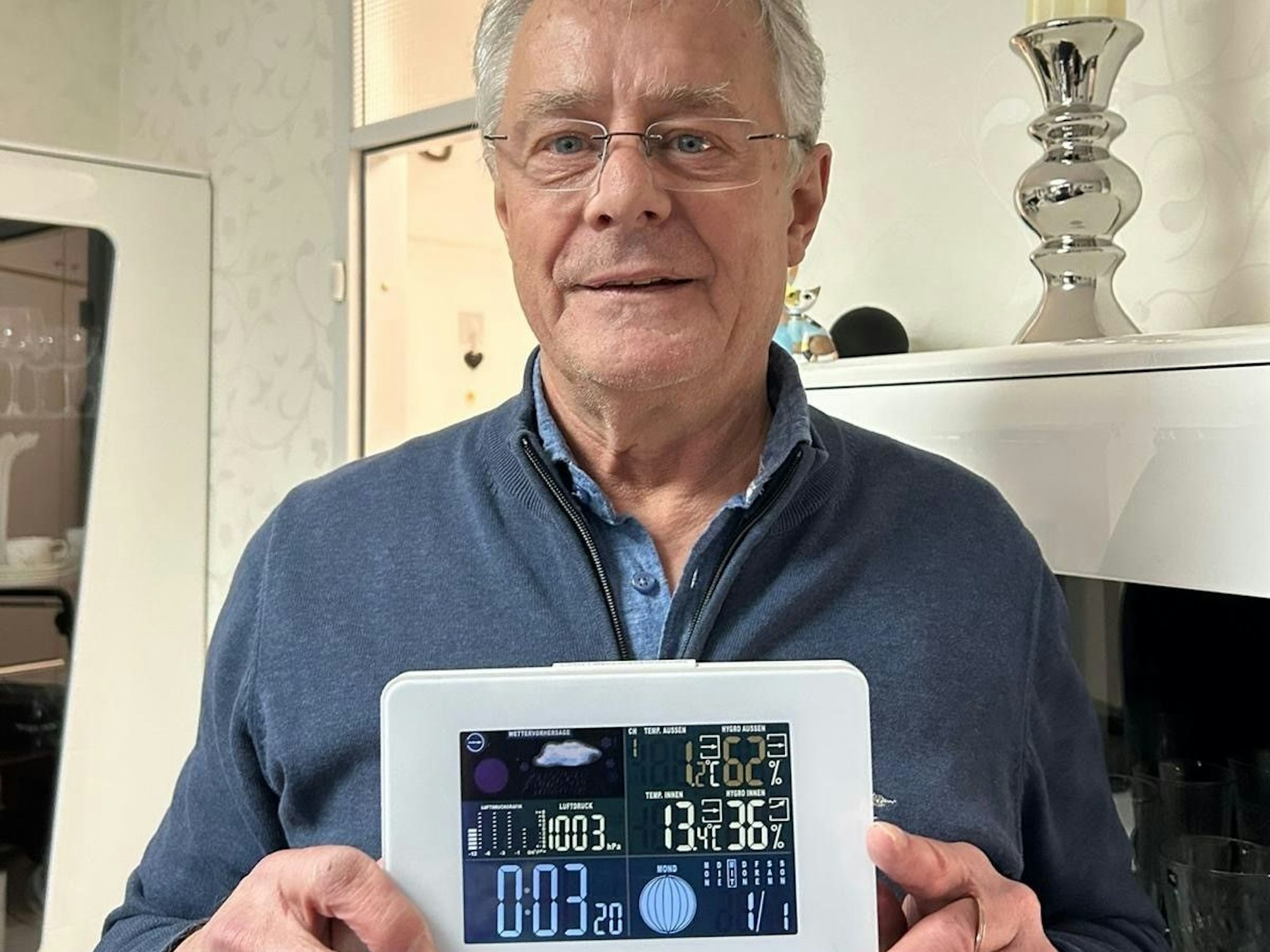 Hans Wirtz hält ein Thermometer, das 13 Grad anzeigt.