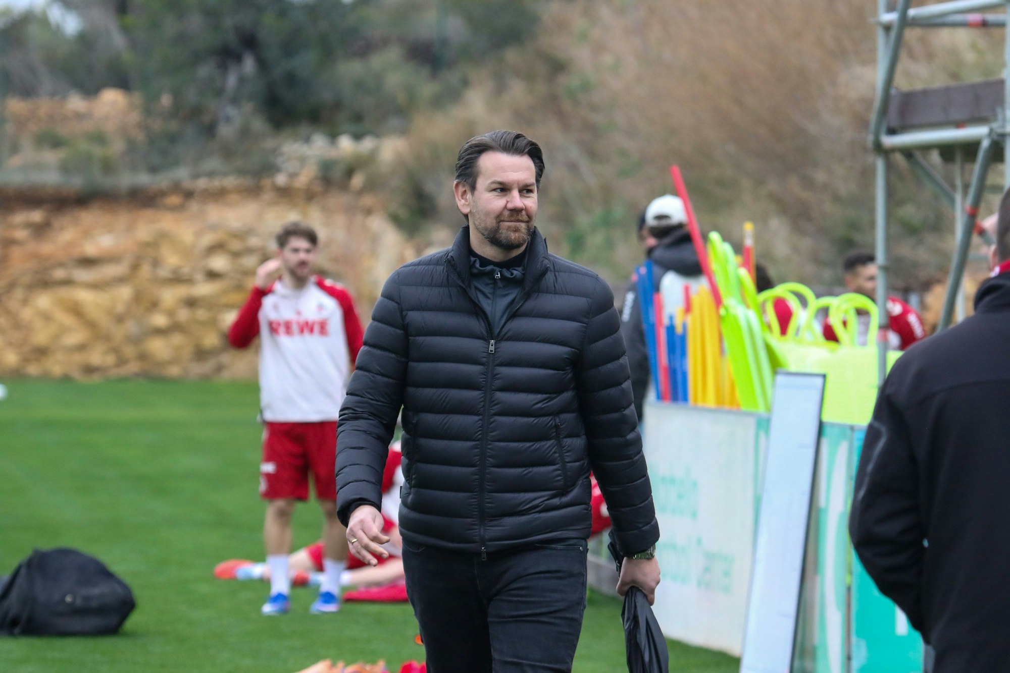 Thomas Kessler geht lächelnd über den Trainingsplatz.