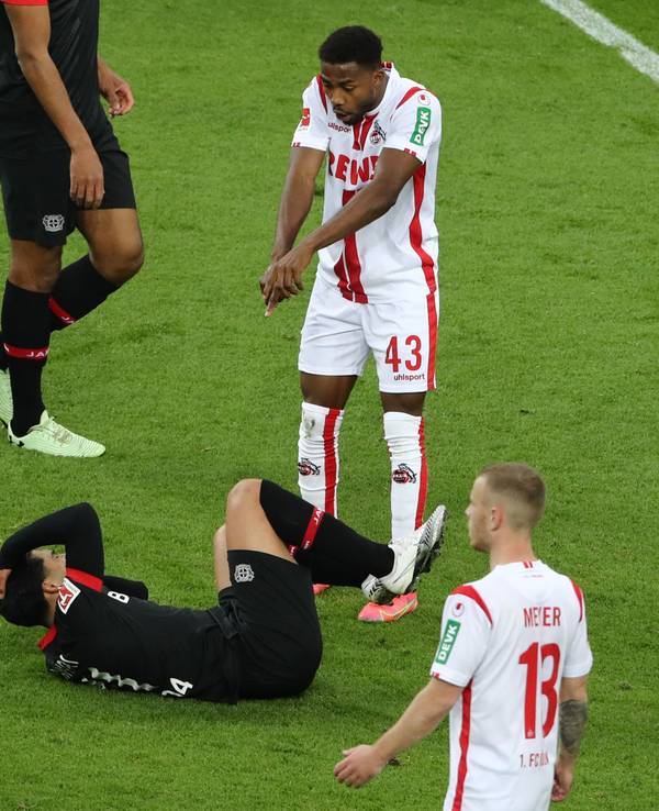 Emmanuel Dennis steht vor einem auf dem Boden liegenden Gegenspieler.