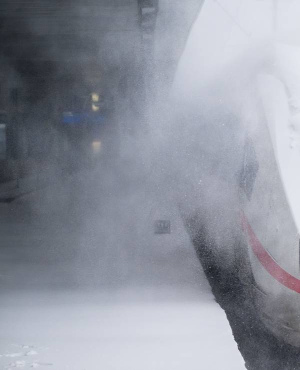 Ein ICE ist zu weiten Teilen von Schnee bedeckt.