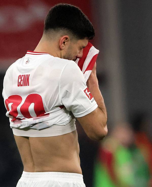 Cenk Özkacar vergräbt sein Gesicht in seinem Trikot.
