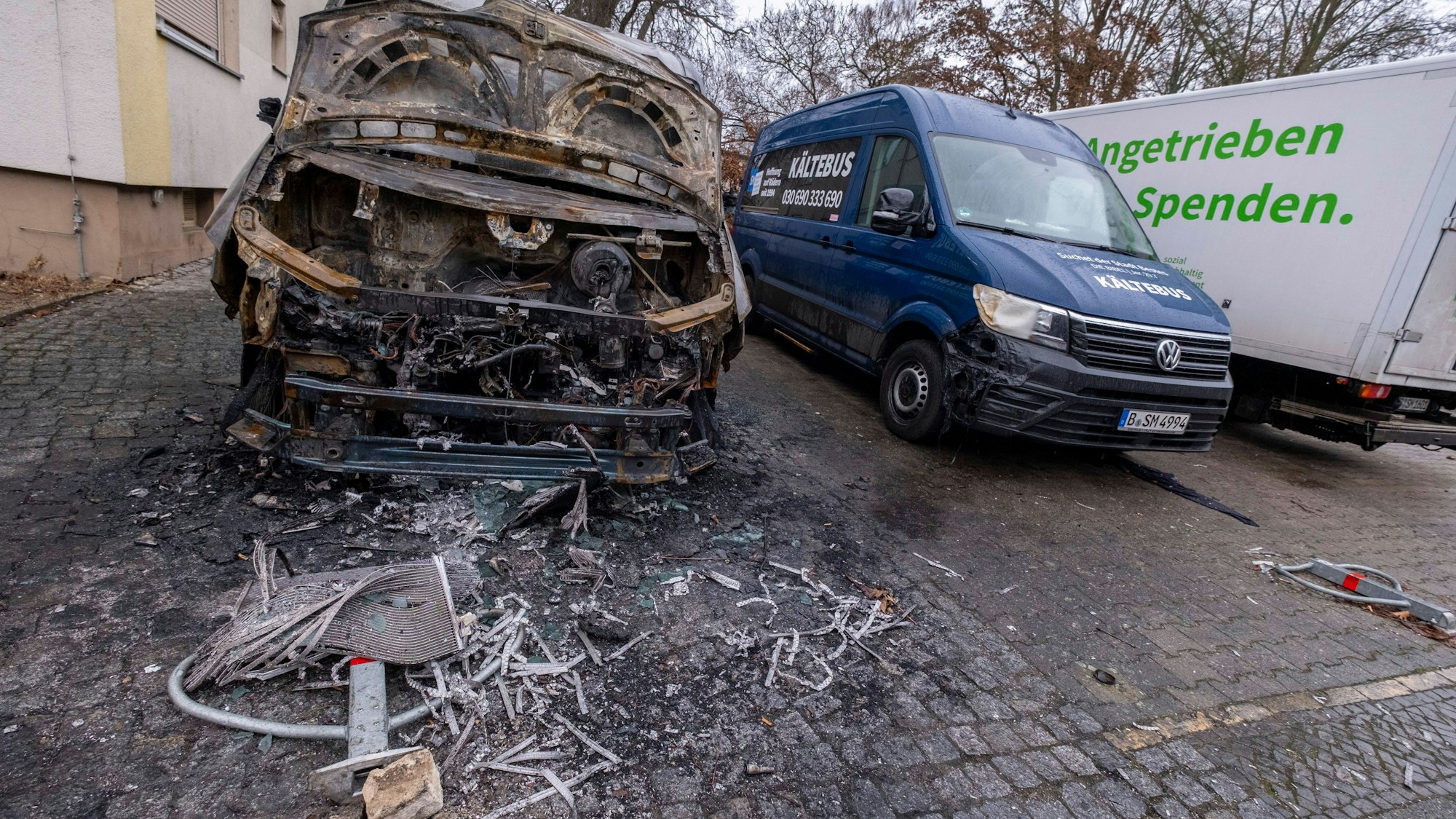 Ausgebranntes Fahrzeug und beschädigter Transporter