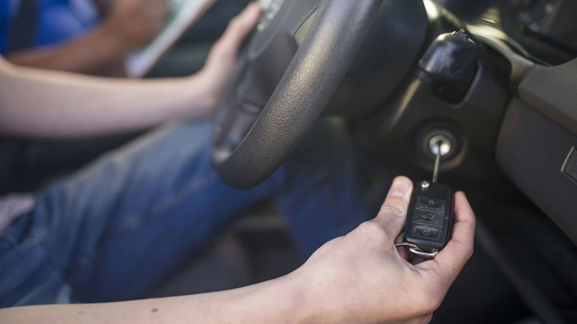 Ein Mann steckt einen Autoschlüssel ins Zündschloss.