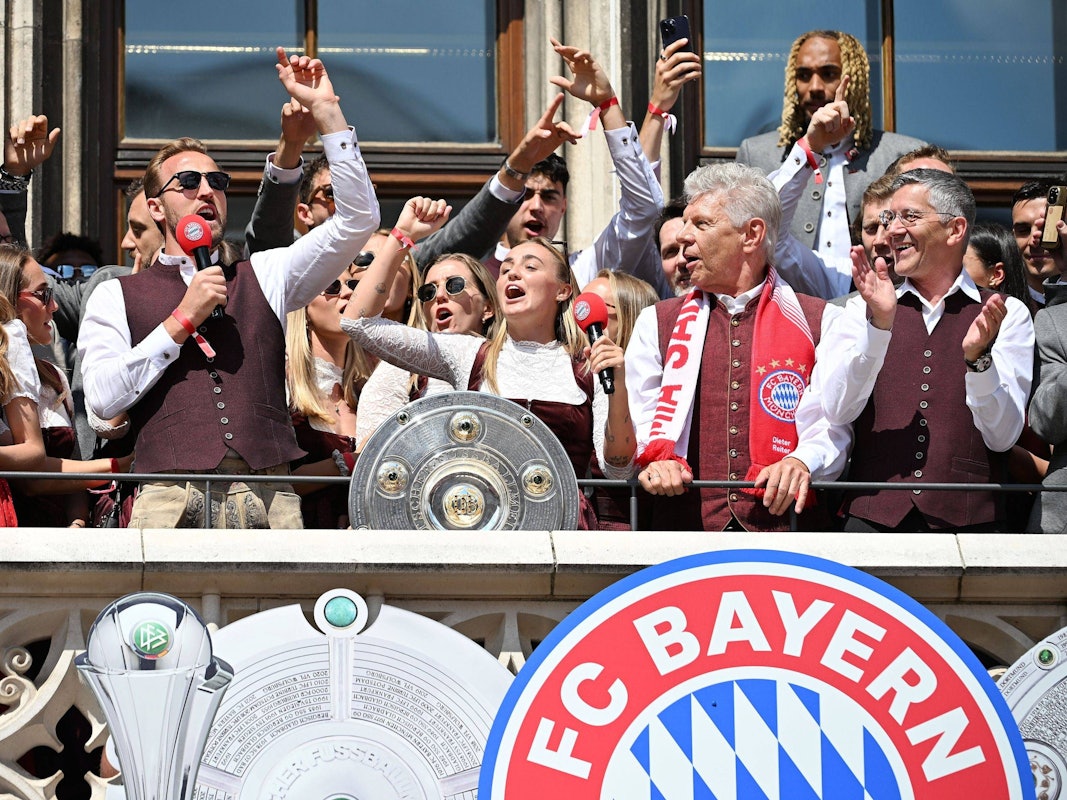 Georgia Stanway und Harry Kane singen gemeinsam auf dem Rathausbalkon in München mit der Meisterschale.