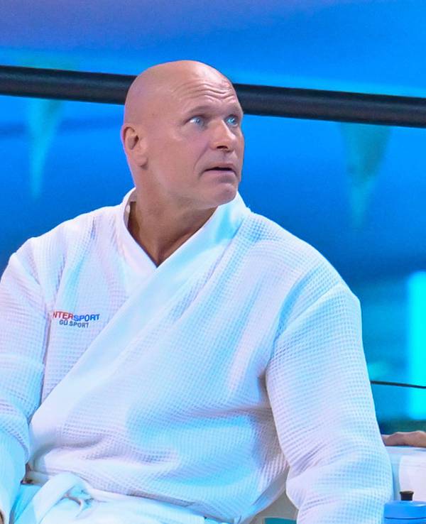 Thorsten Legat sitzt beim Turmspringen im Bademantel am Beckenrand.