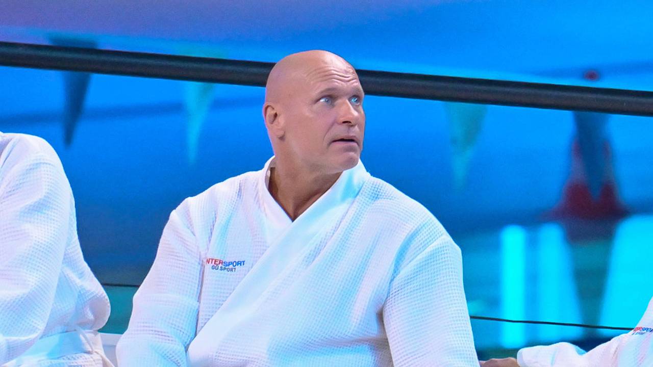 Thorsten Legat sitzt beim Turmspringen im Bademantel am Beckenrand.