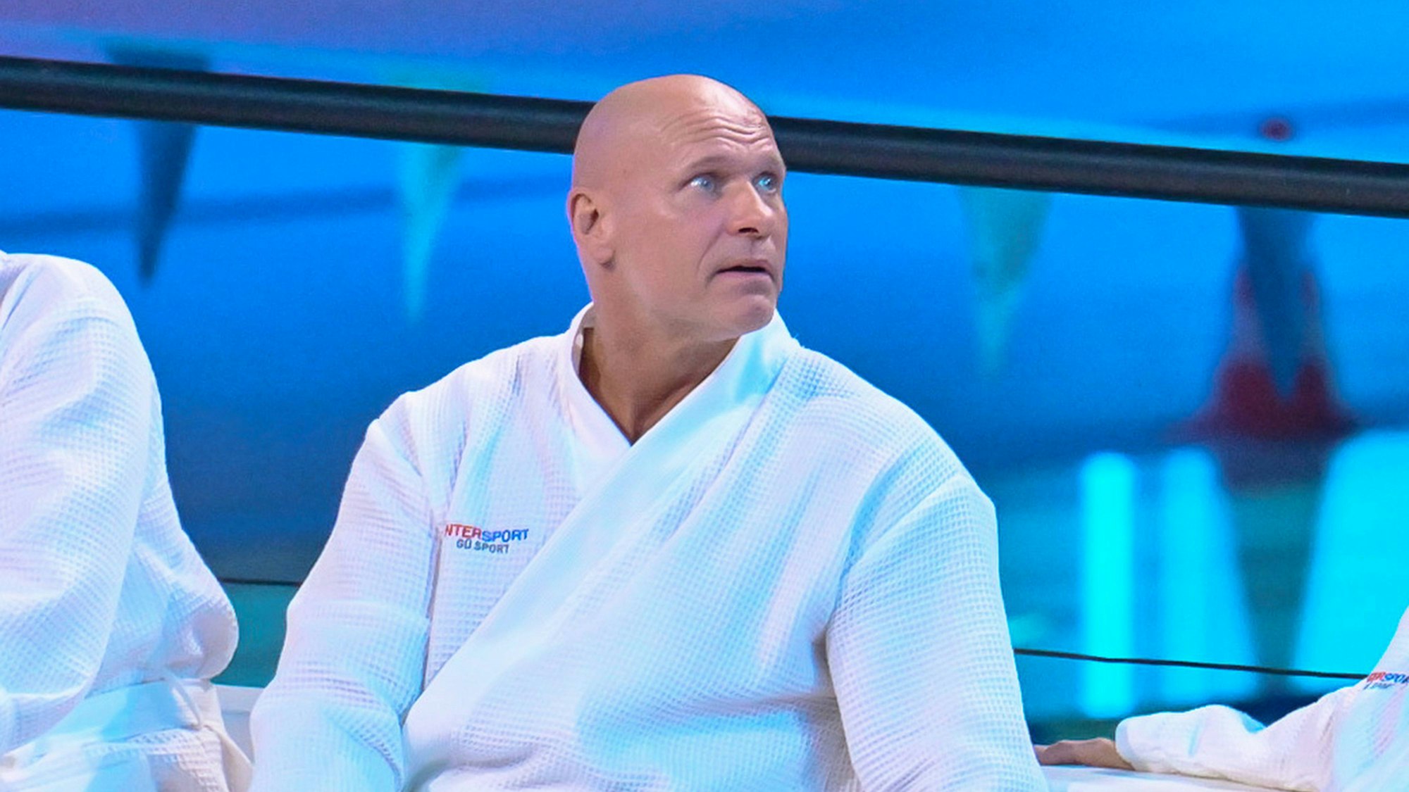 Thorsten Legat sitzt beim Turmspringen im Bademantel am Beckenrand.