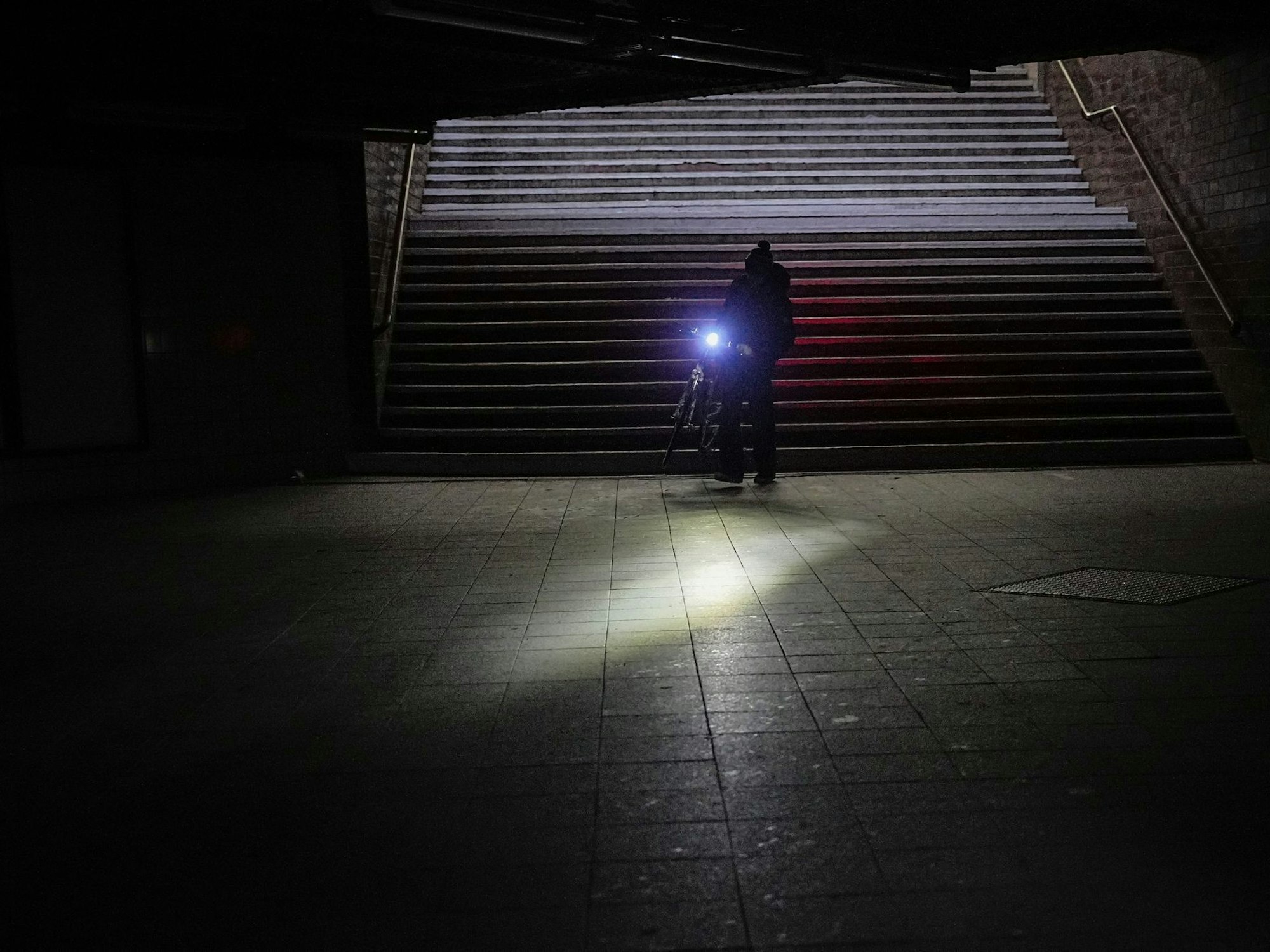 Im Stockdunkeln leuchtet eine Fahrradlampel.