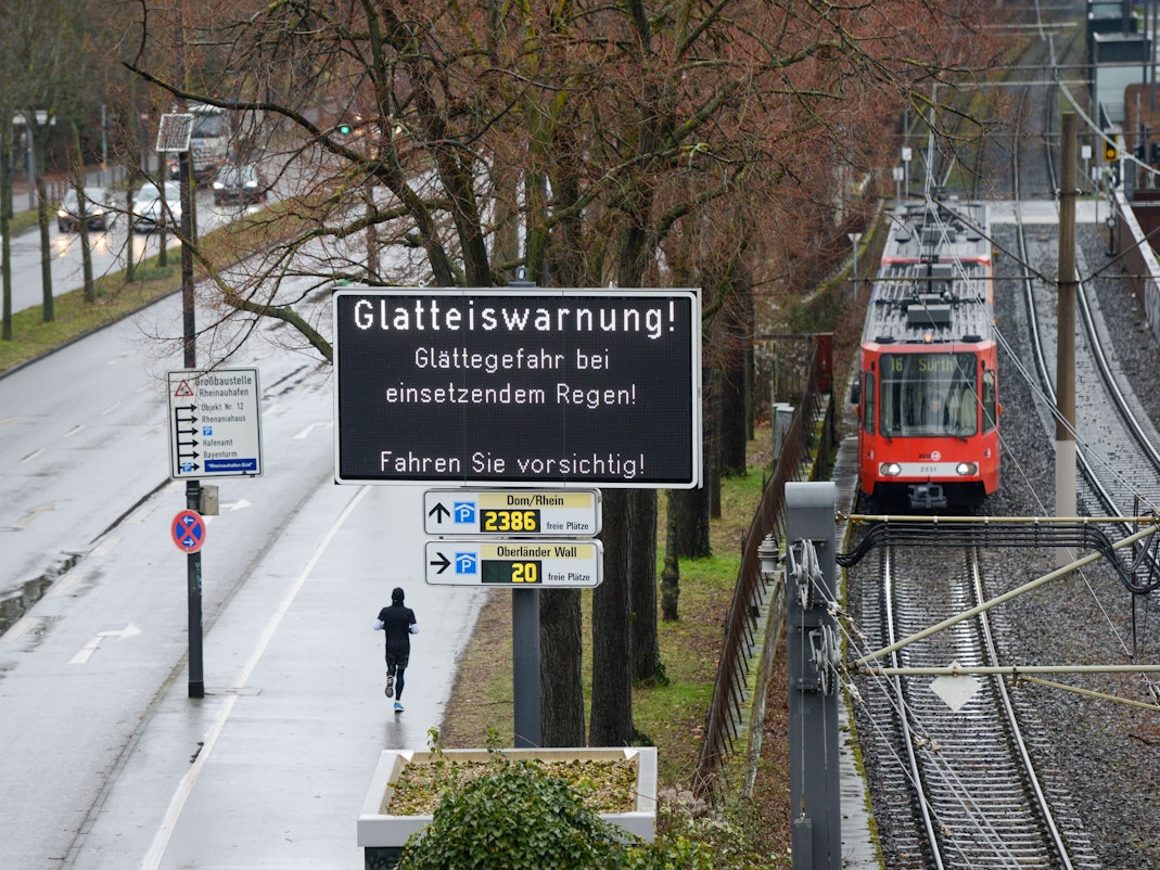 Auf einer LED-Tafel werden Autofahrer und Autofahrerinnen vor der Glatteisgefahr durch überfrierenden Regen gewarnt (Archivfoto). In der Nacht zu Montag droht Blitzeis-Gefahr in Köln.