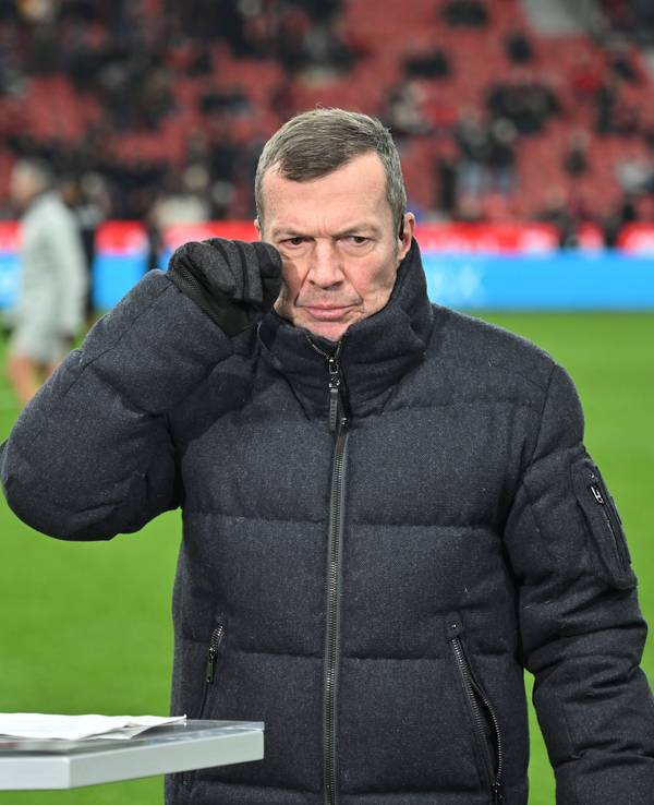 Lothar Matthäus wischt sich mit dem Handschuh über das Gesicht.