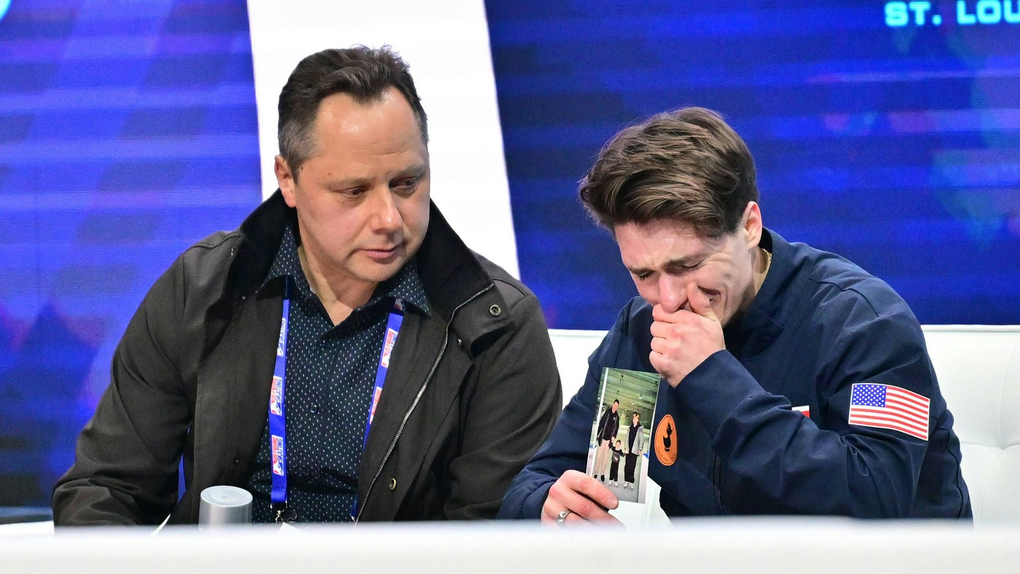 Maxim Naumov hält ein Kinderfoto mit seinen Eltern in die Kamera und weint.