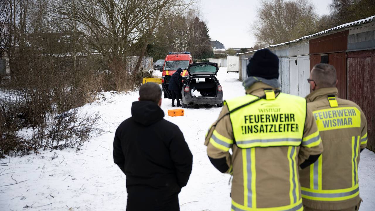 Einsatzkräfte stehen an einem zugefrorenen Gewässer.