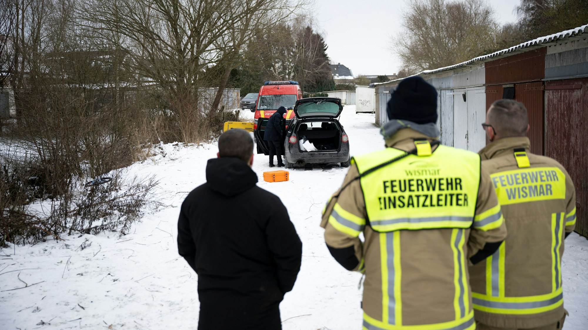 Einsatzkräfte stehen an einem zugefrorenen Gewässer.