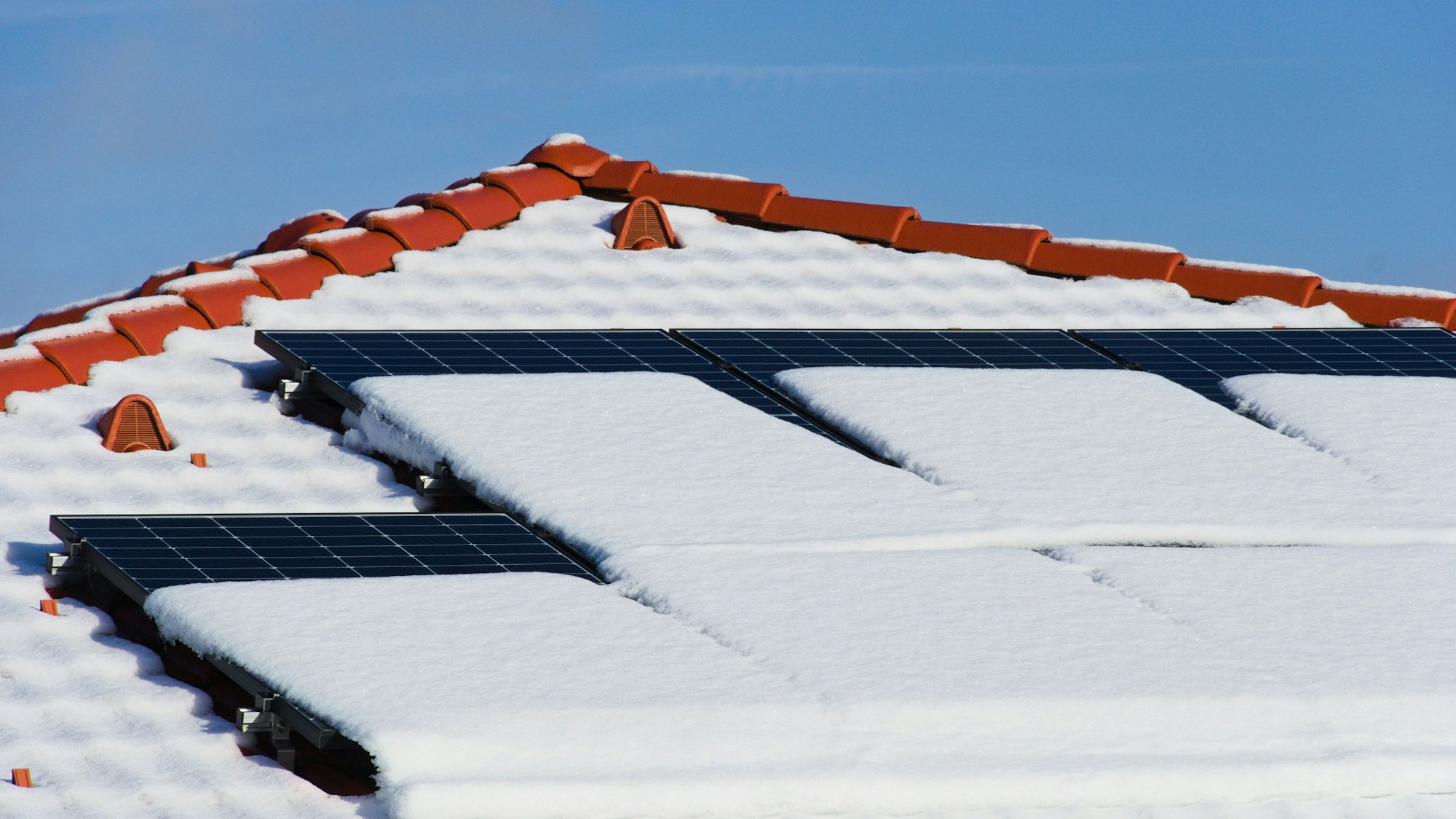 Schneebedeckte Solarmodule auf einem Dach