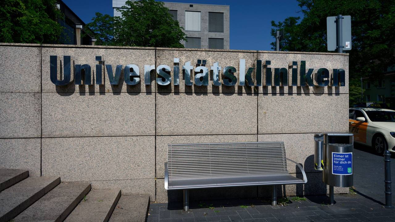 Schriftzug auf einer Steinmauer am Haupteingang des Universitätsklinikums in Köln.